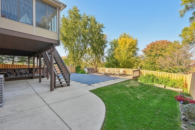 view of yard with a pool side deck, a sunroom, and a patio area