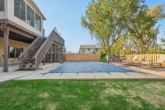 view of swimming pool featuring a deck, a yard, and a patio area