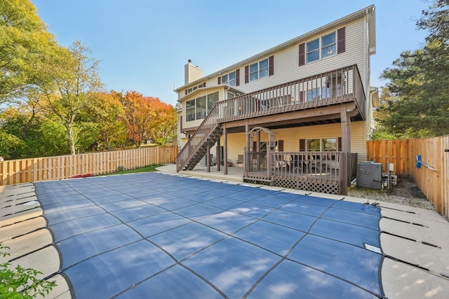 rear view of property featuring a pool side deck and a patio area