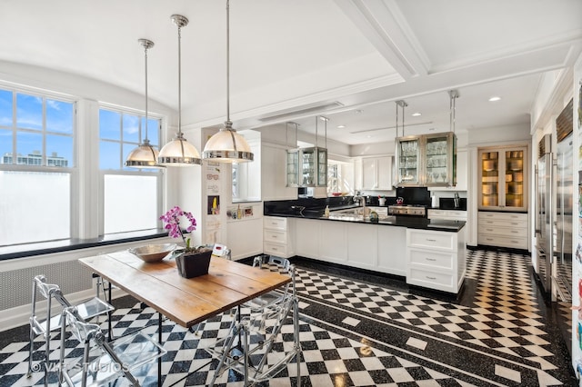 kitchen with stainless steel stove, white cabinets, and decorative light fixtures