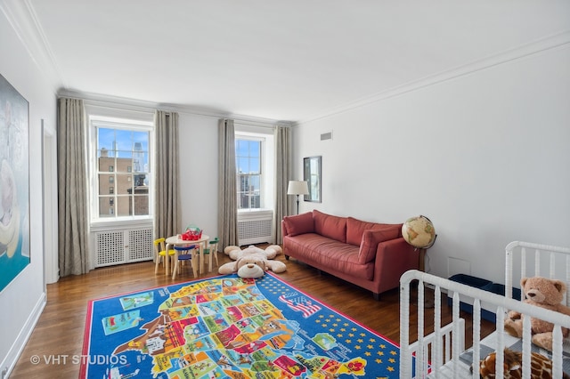 bedroom featuring multiple windows, crown molding, radiator, and dark hardwood / wood-style flooring