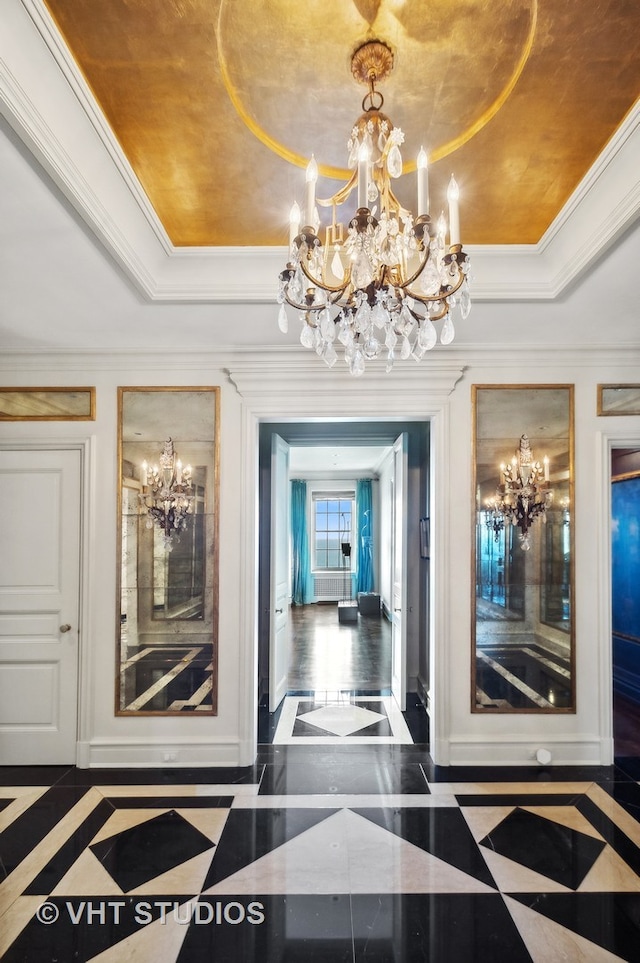 hall featuring a tray ceiling, crown molding, and a chandelier