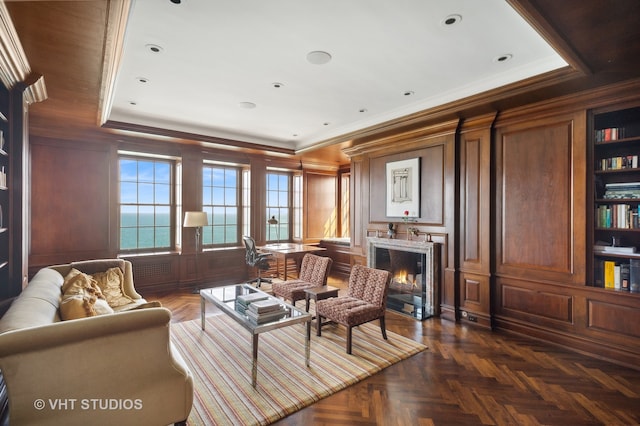 living room featuring a water view, ornamental molding, and dark parquet flooring