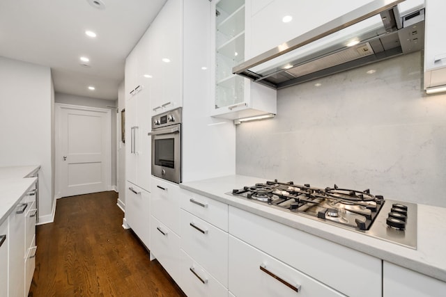 kitchen featuring white cabinetry, appliances with stainless steel finishes, dark hardwood / wood-style flooring, and wall chimney range hood