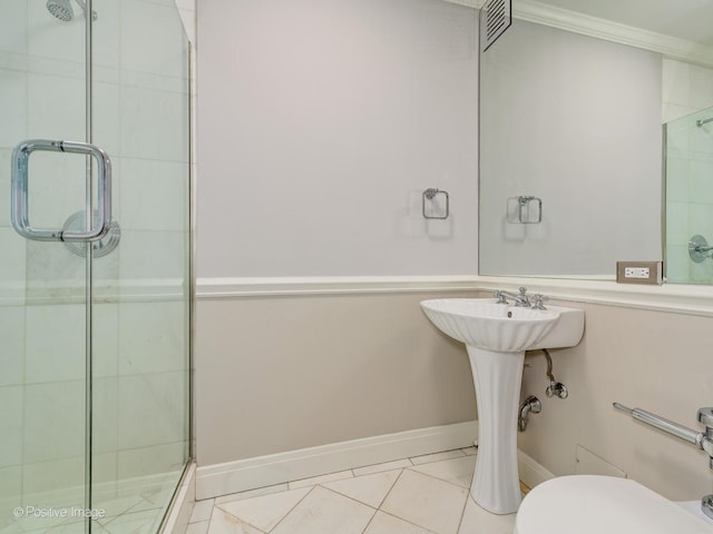 bathroom featuring crown molding, toilet, tile patterned flooring, and a shower with door