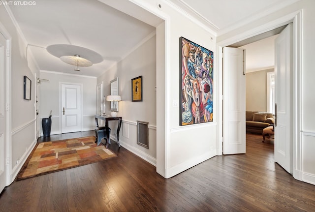 foyer entrance with crown molding and dark hardwood / wood-style flooring