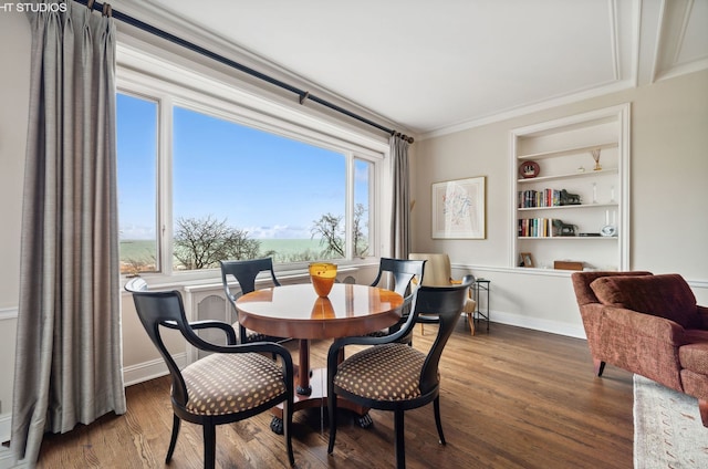 dining space with dark wood-type flooring, built in features, and ornamental molding