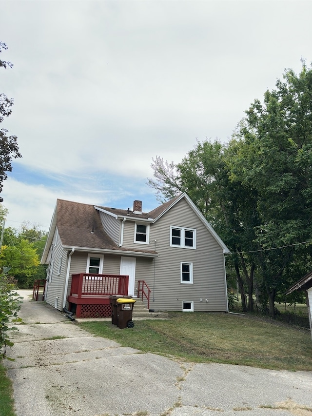 view of front facade with a front lawn and a wooden deck