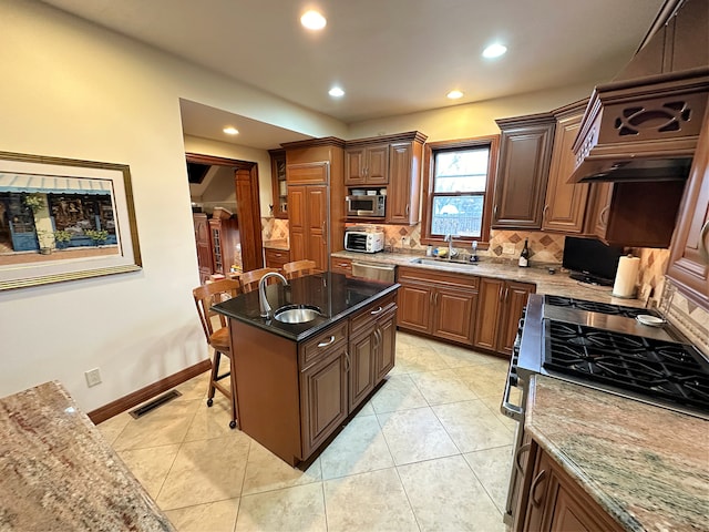 kitchen featuring a kitchen island, backsplash, stainless steel appliances, sink, and light stone counters