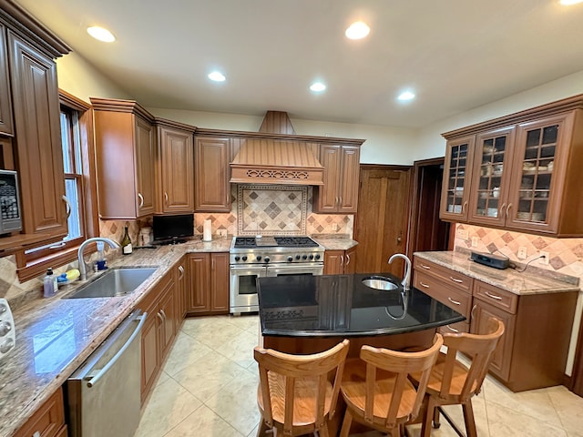 kitchen with appliances with stainless steel finishes, a breakfast bar area, dark stone counters, and sink