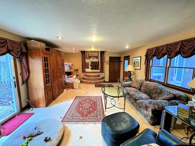 tiled living room featuring a textured ceiling and a healthy amount of sunlight