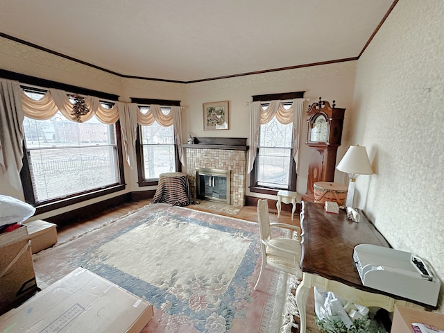 living room with light hardwood / wood-style flooring, ornamental molding, and a tile fireplace