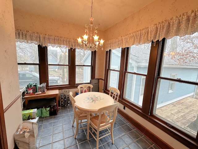 dining space with tile patterned flooring and an inviting chandelier