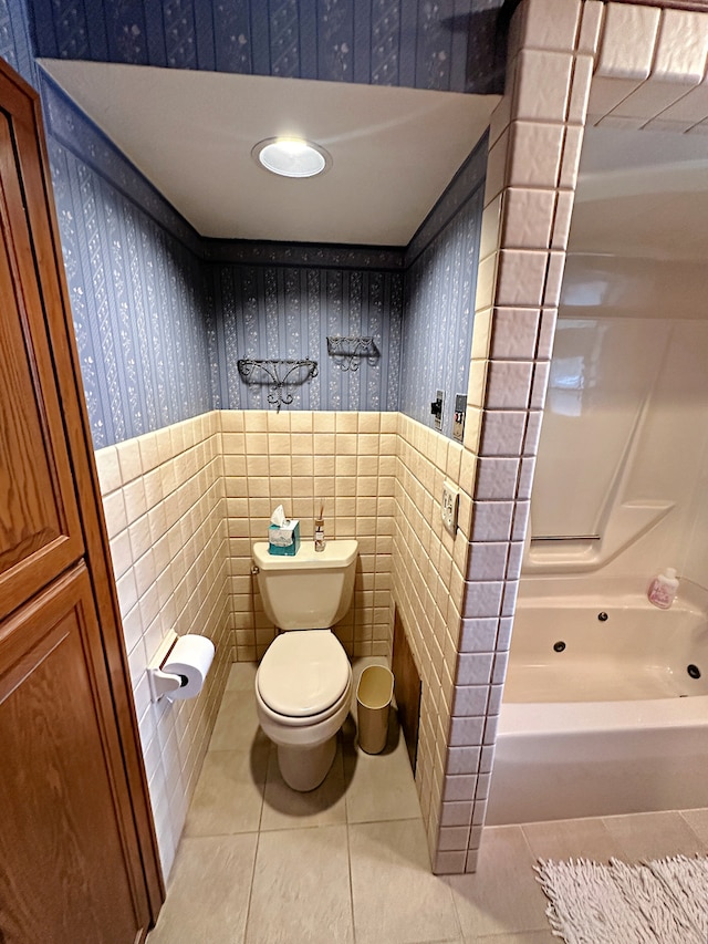 bathroom featuring tile walls, a bathtub, toilet, and tile patterned flooring