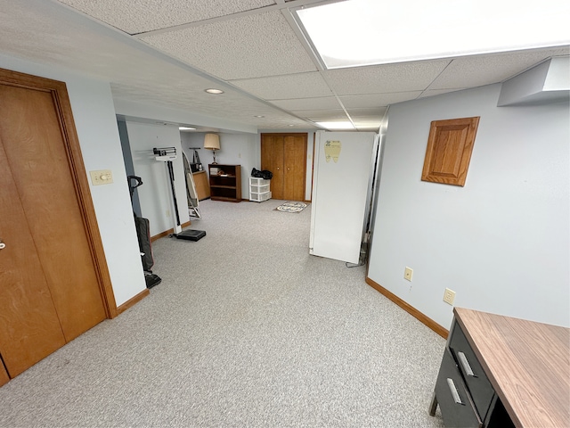 hallway featuring light colored carpet and a drop ceiling