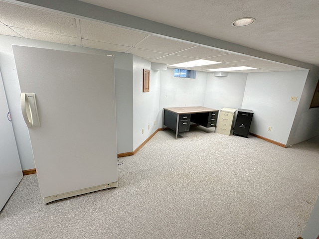 basement with a paneled ceiling and carpet