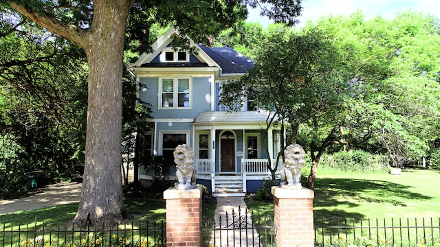 view of front of home featuring covered porch and a front lawn