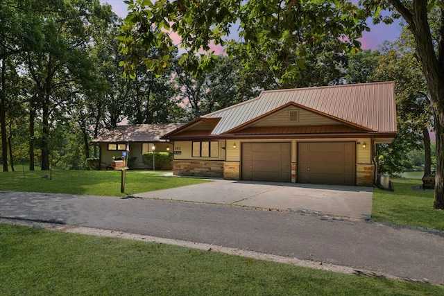 view of front of property with a garage and a yard