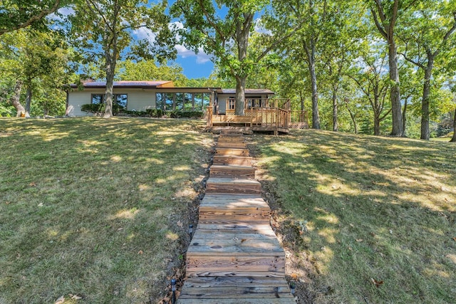 back of house featuring a lawn and a wooden deck