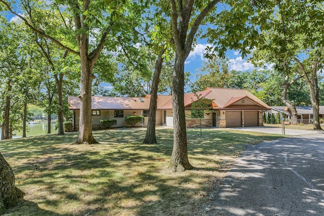 ranch-style house featuring a garage and a front lawn