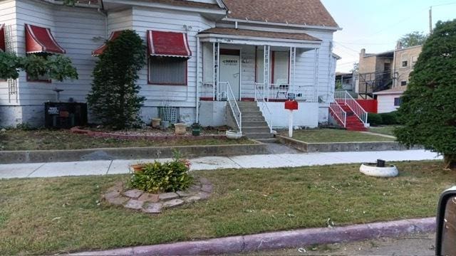 view of front of home featuring central AC unit and a front lawn