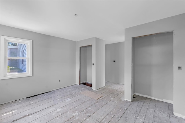 unfurnished bedroom with light wood-type flooring and a closet