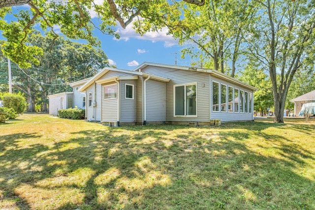 back of property with a sunroom and a yard