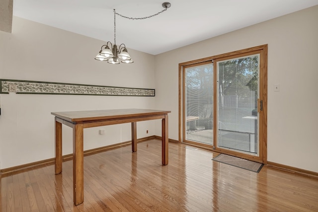 unfurnished dining area with a chandelier and light hardwood / wood-style floors