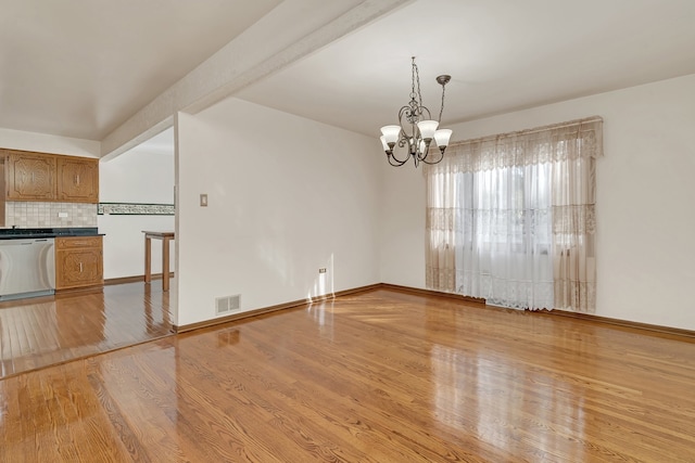 interior space with light hardwood / wood-style flooring, a chandelier, and beam ceiling