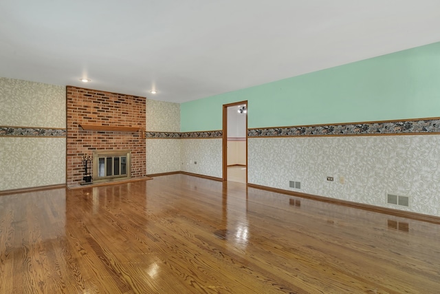 unfurnished living room featuring hardwood / wood-style flooring and a fireplace