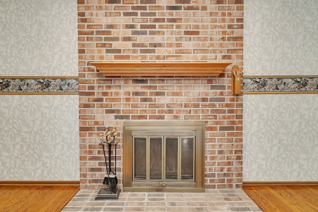 interior details featuring hardwood / wood-style floors and a brick fireplace