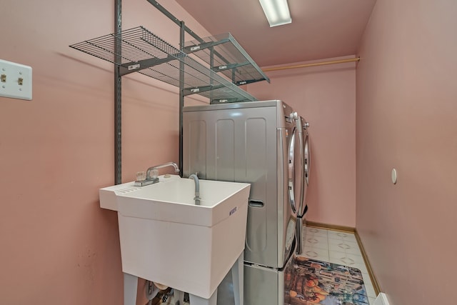 clothes washing area featuring washer and clothes dryer and sink