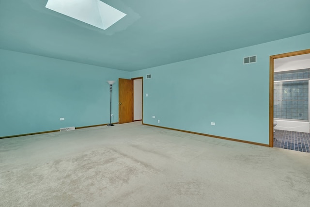 carpeted empty room with a skylight