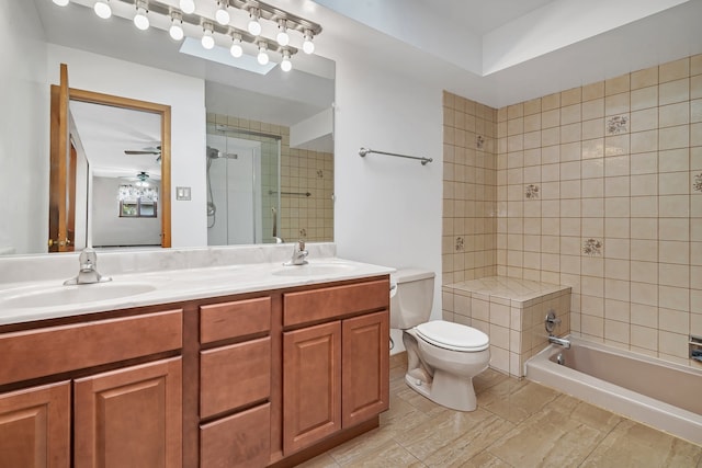 full bathroom featuring tiled shower / bath, vanity, toilet, and ceiling fan