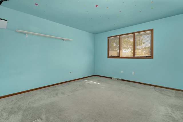 empty room with vaulted ceiling and carpet flooring