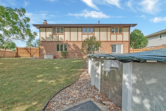 rear view of property featuring a lawn