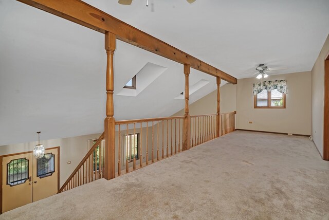 unfurnished room featuring ceiling fan, light carpet, and vaulted ceiling with beams