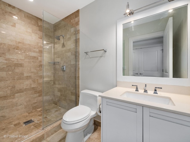 bathroom featuring a shower with door, vanity, and toilet