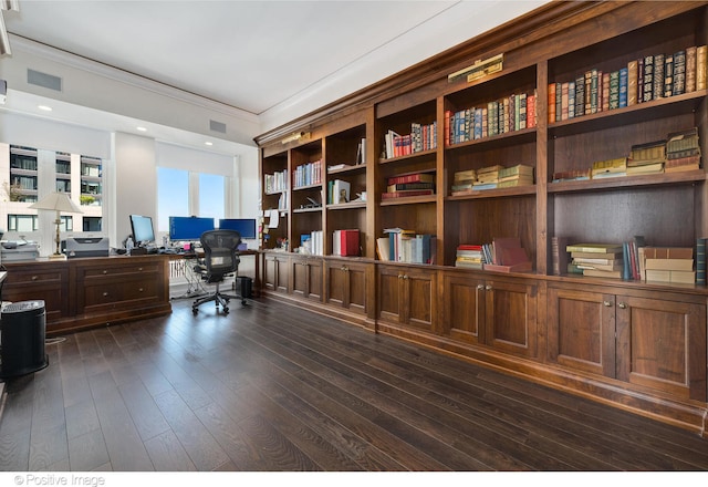 office space with dark wood-type flooring, ornamental molding, and built in desk