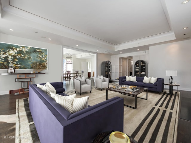 living room featuring a chandelier, a tray ceiling, and hardwood / wood-style flooring