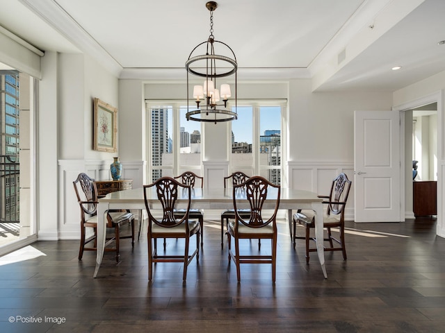 dining space with an inviting chandelier, crown molding, and dark hardwood / wood-style flooring