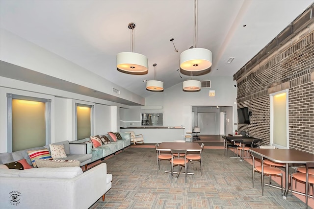 interior space featuring brick wall and high vaulted ceiling