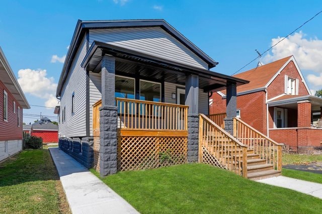 bungalow-style home featuring a porch and a front yard