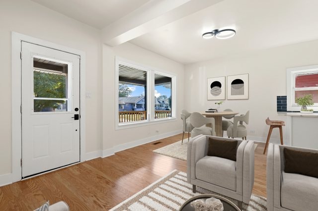 interior space featuring beamed ceiling, a healthy amount of sunlight, and light hardwood / wood-style flooring