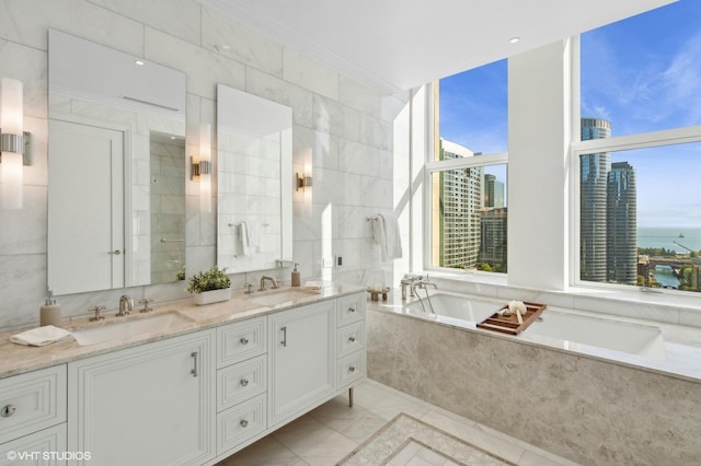 bathroom with vanity, tile walls, tiled bath, and a water view