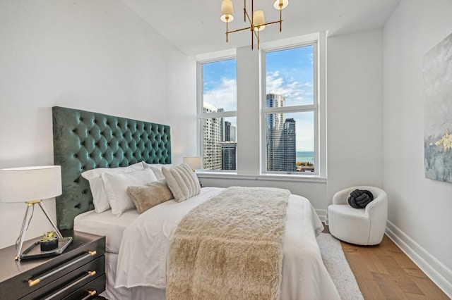 bedroom featuring a chandelier and wood-type flooring