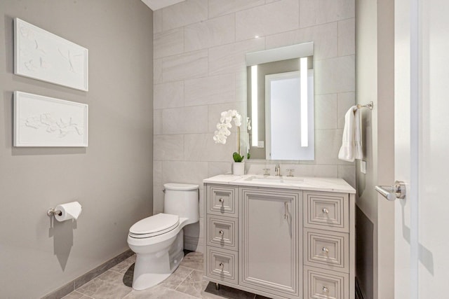 bathroom featuring tile walls, toilet, and vanity