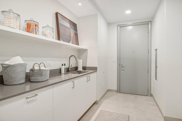 bar featuring sink and white cabinetry