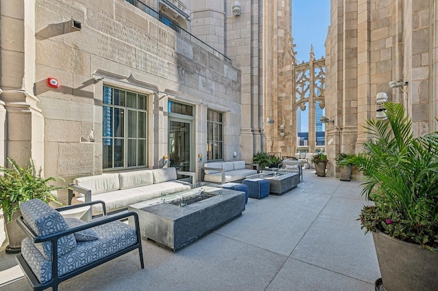 view of patio with an outdoor living space with a fire pit