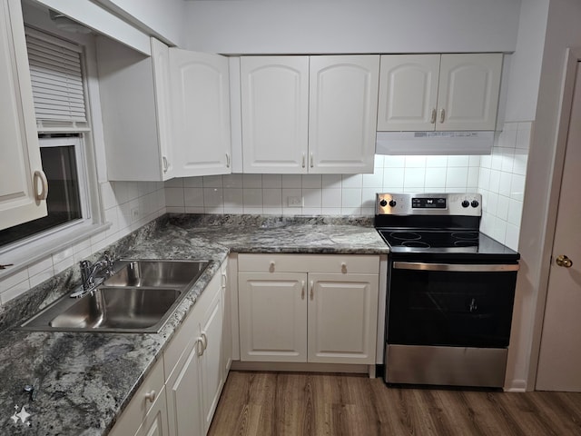 kitchen with electric stove, white cabinetry, and sink